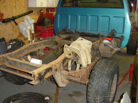 1987 Suzuki Samurai - The rear section of a truck is shown with the body removed, revealing the chassis and suspension components.