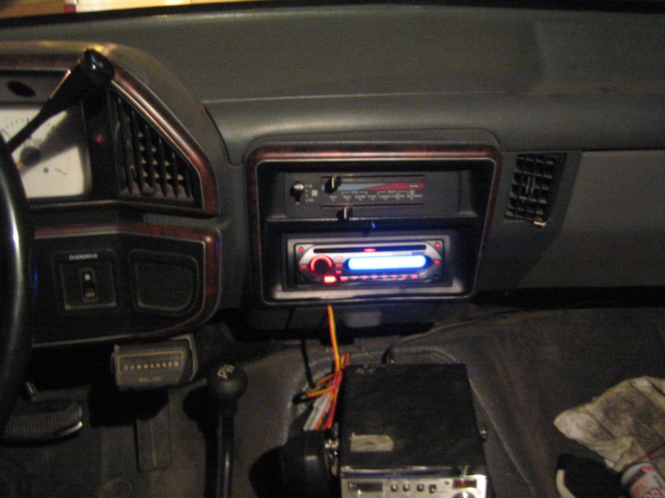 Aftermarket car stereo head unit installed in a dark vehicle dashboard