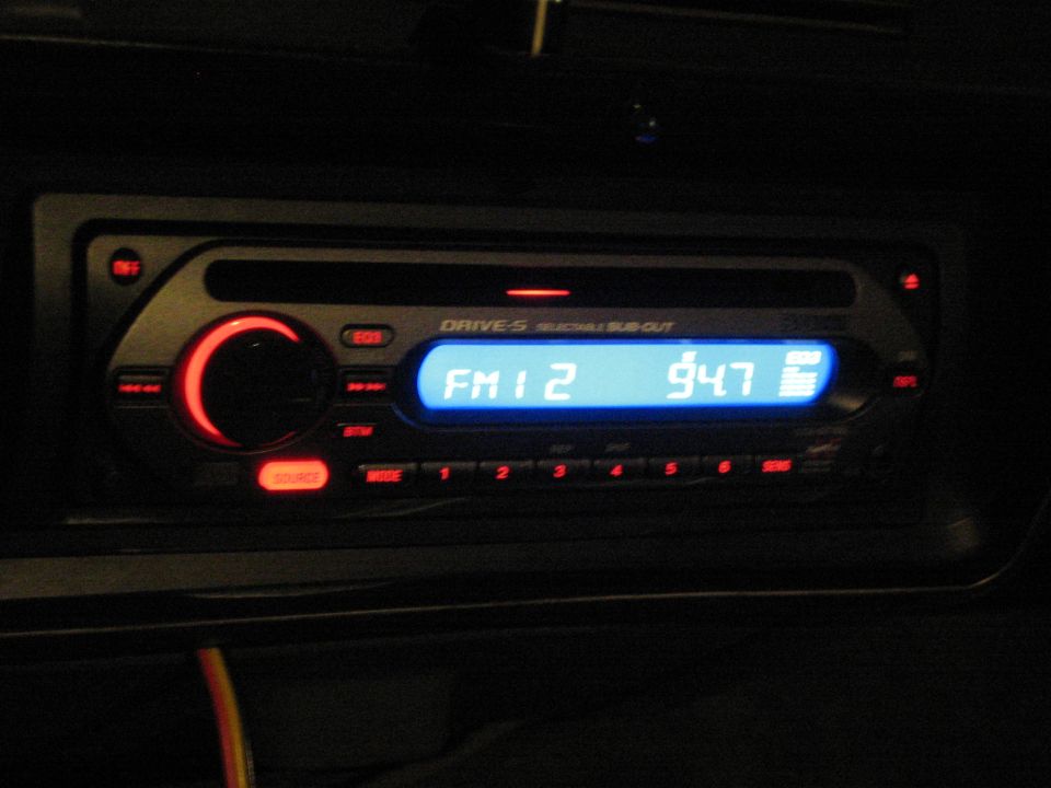 Close-up of illuminated car stereo display reading FM1 2 and 947