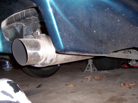 1997 Ford Probe - The rear of a vehicle is shown, focusing on the exhaust system and undercarriage, supported by jack stands.