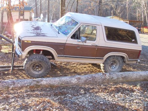1982 Ford Bronco - This lifted Ford Bronco navigates an off-road obstacle course with a large log in its path.