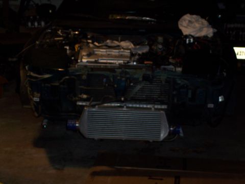 1997 Ford Probe - The front end of a vehicle is disassembled, revealing the engine and an aftermarket intercooler.