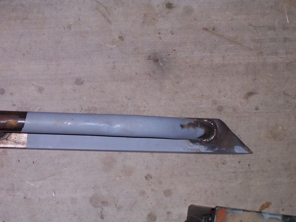 Metal part with grey paint and visible welds at the end