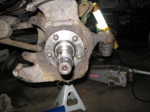 1995 Ford Bronco - Wheel bearing assembly on jack stands, with a floor jack in the background.
