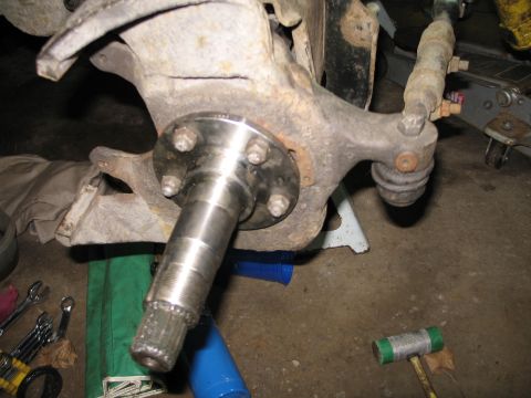 1995 Ford Bronco - This photo shows a vehicle's wheel hub and suspension components, with tools scattered nearby.