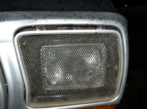 1979 Ford Bronco - Headlight assembly with a protective mesh cover, likely a custom modification.