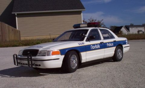 1998 Ford Crown Victoria - This 1998 Ford Crown Victoria police car features a white body with a blue stripe and "Norfolk Police" text on the door.