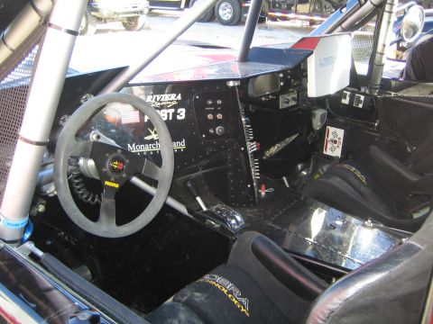 1990 Ford Bronco - Stripped racing interior of an off-road truck showing a suede steering wheel, switch panel and welded roll cage with Riviera and Monarch La…
