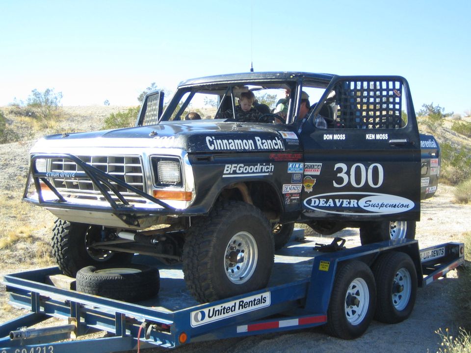 Black Ford Bronco race truck number 300 strapped on a flatbed trailer