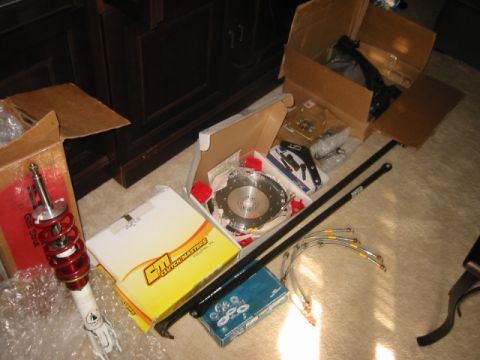 1993 Ford Probe - Various automotive parts, including a Clutch Masters clutch kit and a shock absorber, are displayed on a carpeted floor.