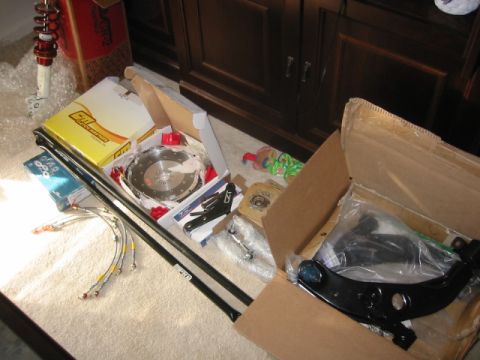 1993 Ford Probe - Various automotive parts are unpacked and arranged on a carpeted surface, ready for installation.