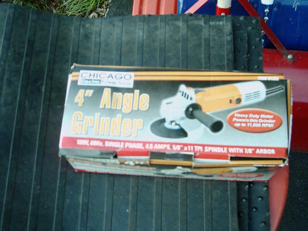 Boxed Chicago Electric 4-inch angle grinder on a black rubber mat