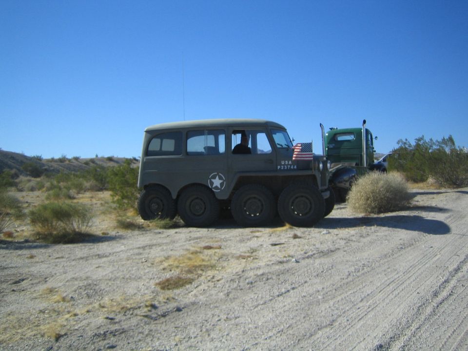 Olive-drab military 8x8 wheeled vehicle with USA markings in the desert