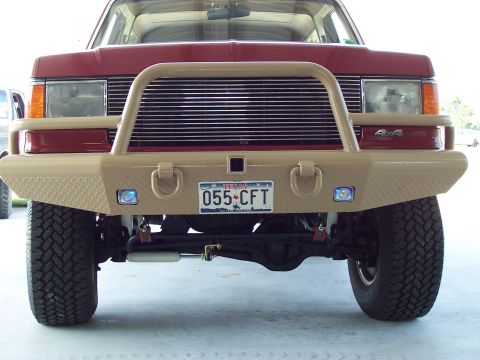 1989 Ford Bronco - This SUV features a tan aftermarket bumper and brush guard, with '4x4' badging visible on the fender.