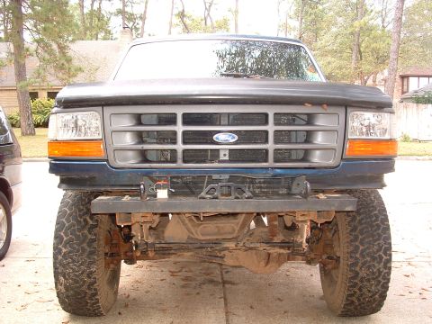 1993 Ford Bronco - Frontal view of a blue 1993 Ford Bronco, its grille, headlights, and a winch mounted on the aftermarket bumper.