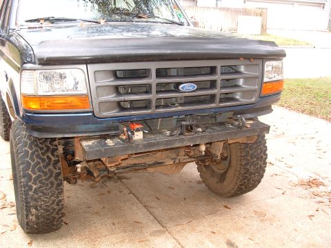 1993 Ford Bronco - Ford Bronco front end shows aftermarket bumper and winch. The grille and headlights are visible.