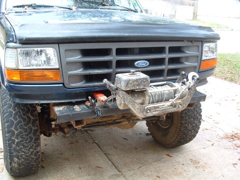 1993 Ford Bronco - A dark blue 1992 Ford Bronco's front end is visible, equipped with a winch.
