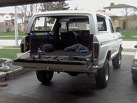 1978 Ford Bronco - Rear view of a white 1978 Ford Bronco with its tailgate open, revealing tools and cargo area.
