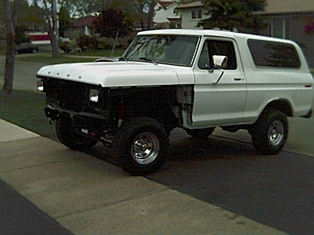 White 1978 Ford Bronco parked on a driveway, front fenders removed