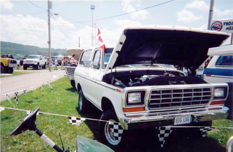 1978 Ford Bronco - 1978 Ford Bronco on display at an outdoor car show, engine visible under the open hood.
