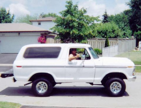 1978 Ford Bronco - A white 1978 Ford Bronco is captured in a side profile shot on a sunny day.