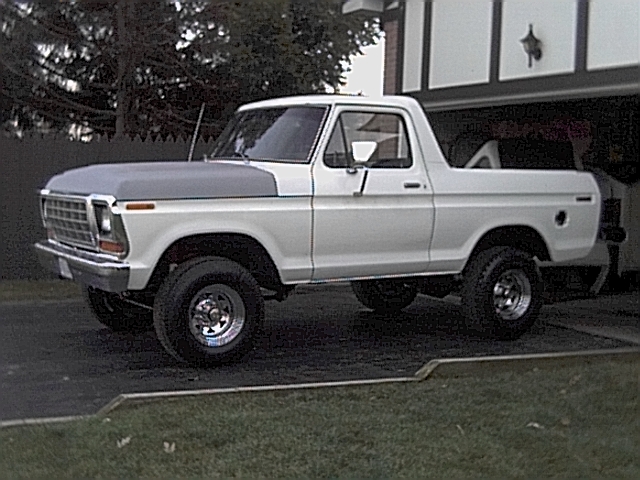 White 1978 Ford Bronco with grey hood parked outside