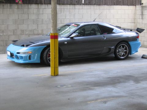 1993 Ford Probe - This modified sports car features a two-tone paint scheme with a blue front bumper and rear valence, and a prominent rear wing.