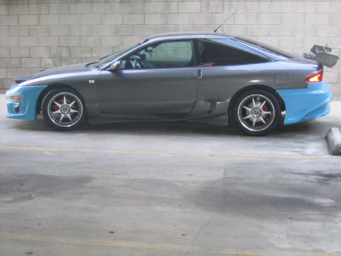1993 Ford Probe - Side view of a modified 1993 Ford Probe a large rear spoiler and contrasting blue body kit sections.