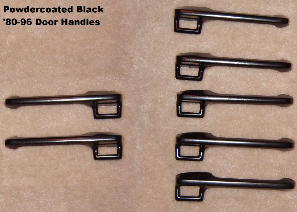 Seven powdercoated black exterior door handles arranged on tan carpet, labeled '80-96