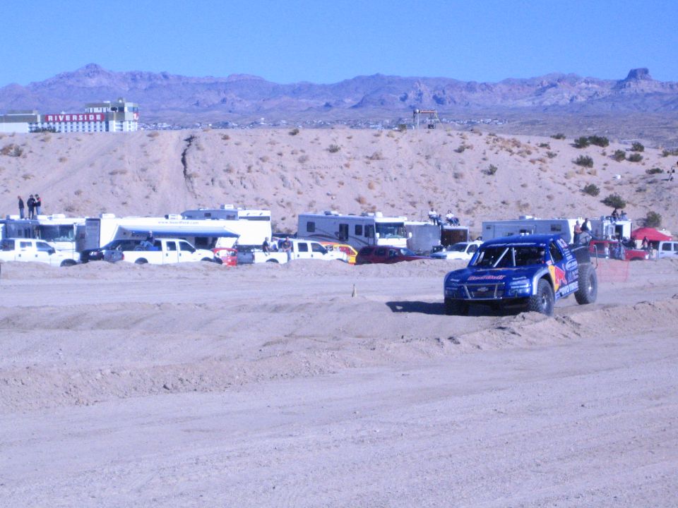 Blue Red Bull-liveried off-road race truck on a sandy desert course