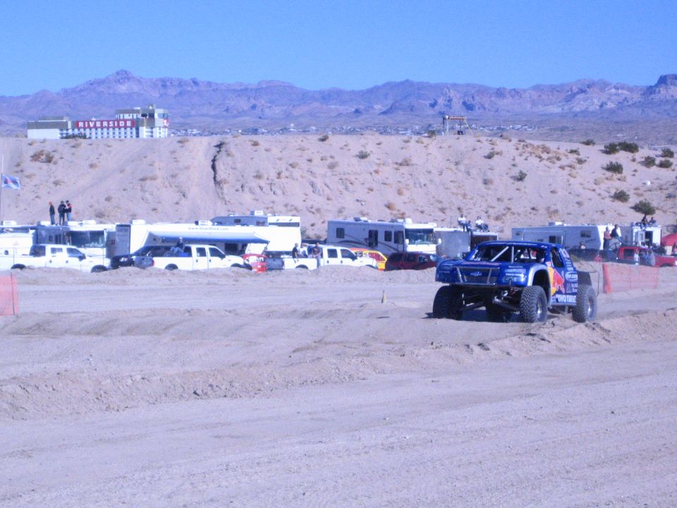 Blue Red Bull-liveried off-road truck on big tires on a desert dirt course
