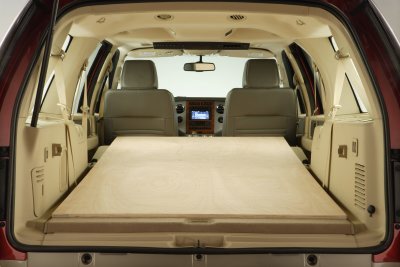 1991 Ford LTD Crown Victoria - The interior cargo area of a vehicle is shown with a wooden platform covering the floor and the front seats visible.