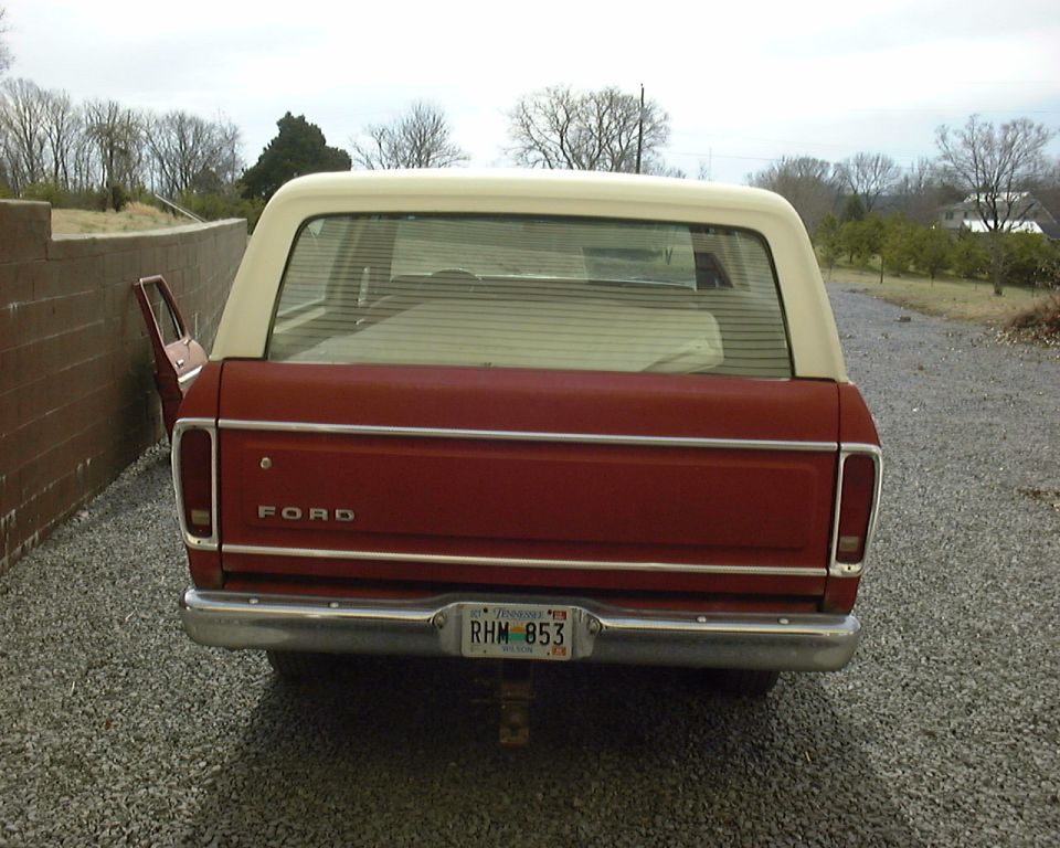 Rear view of a 1978 Ford Bronco, red with white top. License plate reads RHM 853