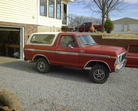 1978 Ford Bronco - Red 1978 Ford Bronco with white top parked outside a house and garage.
