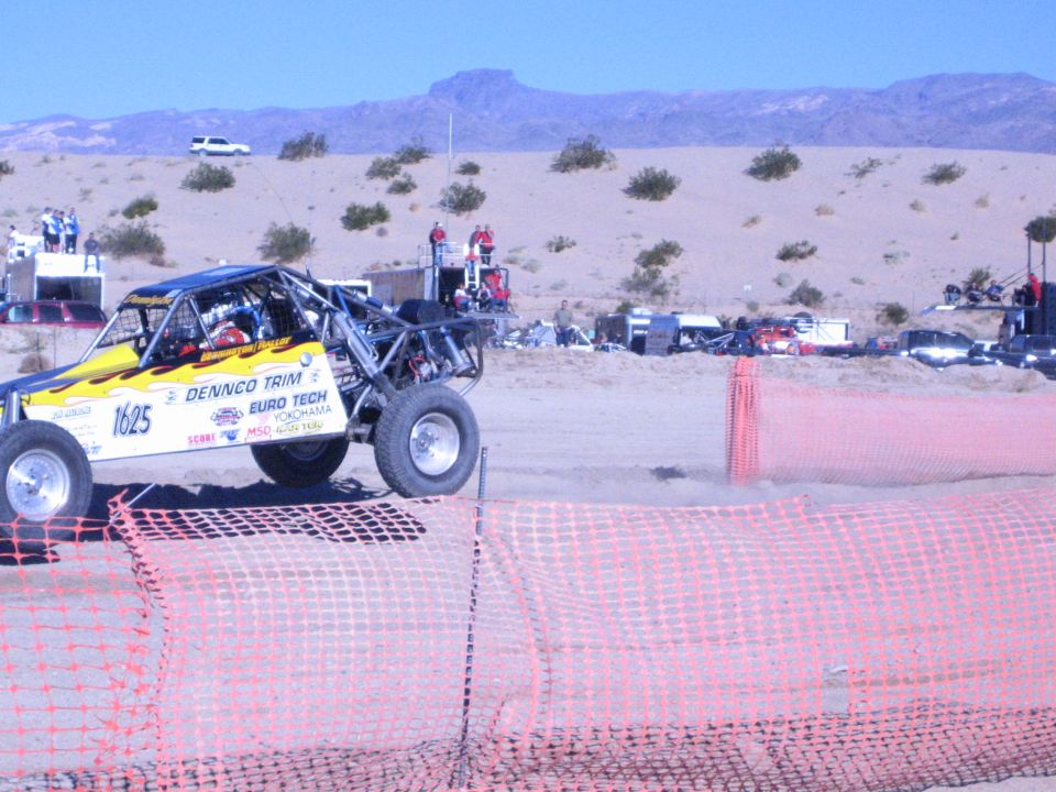 Yellow off-road buggy number 1625 with Dennco Trim livery on a desert race course