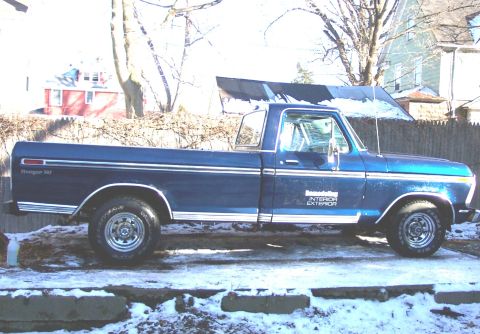 1975 Ford F-150 - This blue 1975 Ford F-150 Ranger XLT pickup truck is parked outside in the snow.