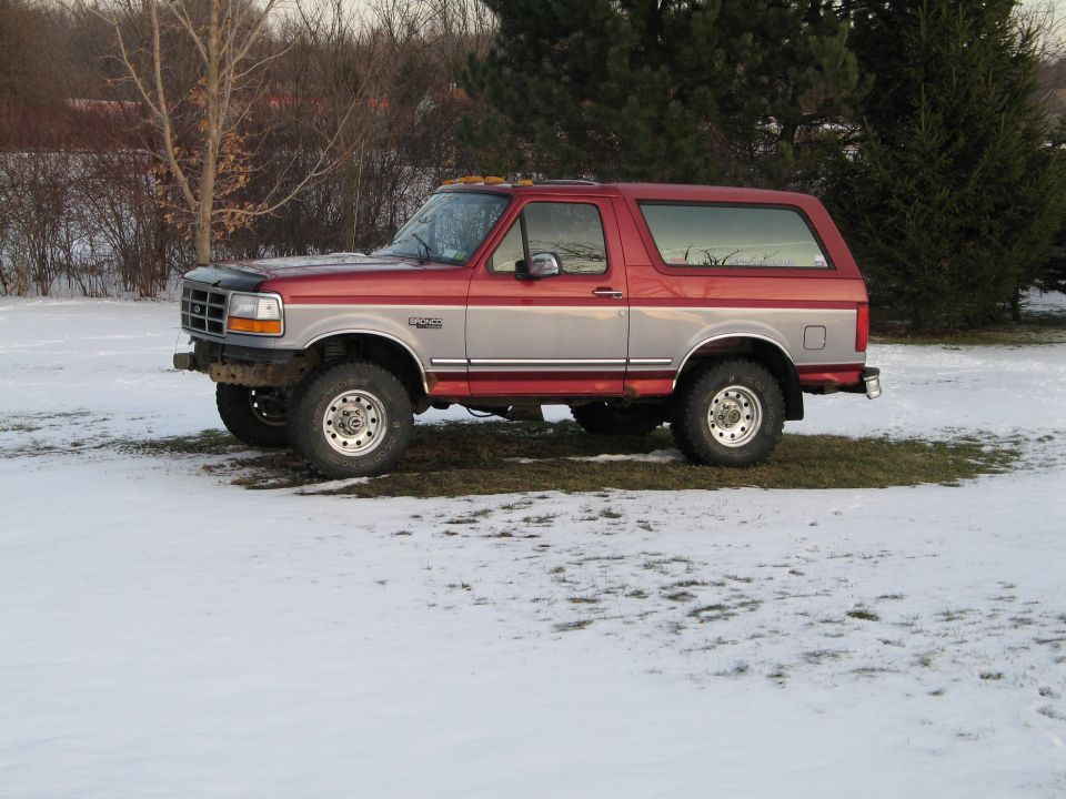 Red and silver 1995 Ford Bronco in snow, side view