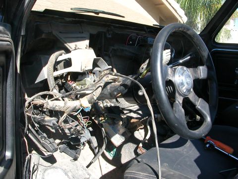 1984 Ford Bronco - The dashboard wiring harness of a 1984 Ford Bronco is exposed, with the steering wheel visible.
