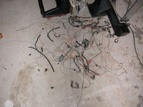 1984 Ford Bronco - A pile of disconnected vehicle wiring components lies on the floor, suggesting a disassembly or repair process.