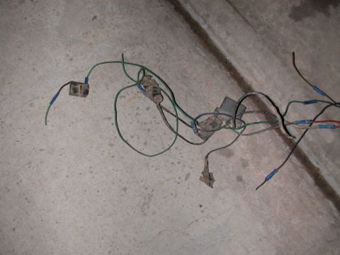 1984 Ford Bronco - A tangled wiring harness with various connectors and a small black box lies on a concrete floor.