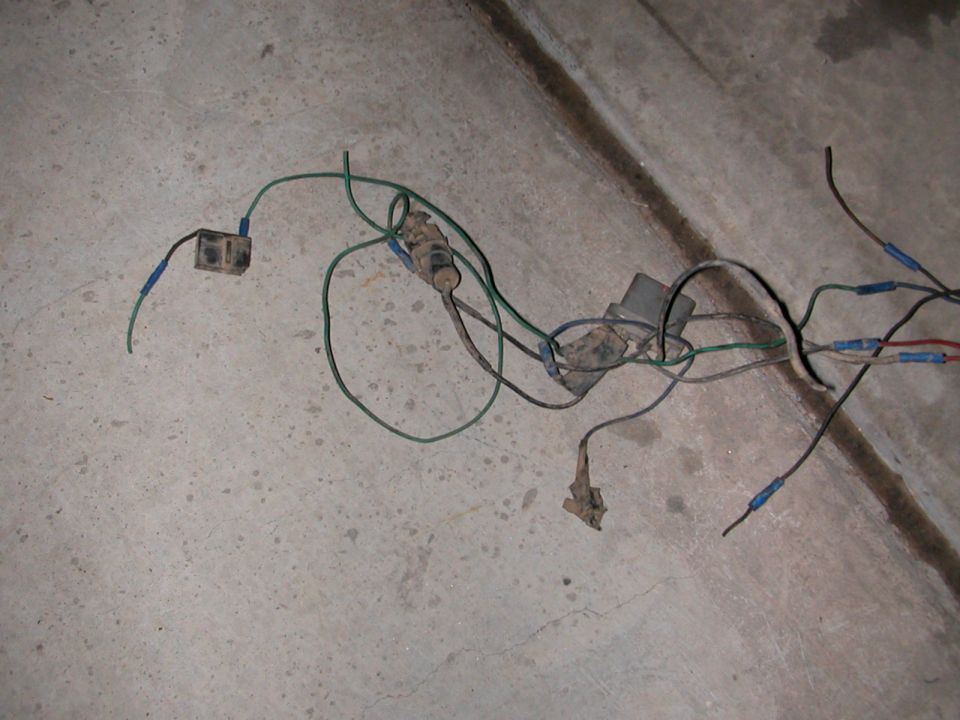 Wiring harness with connectors and a black box on a concrete surface