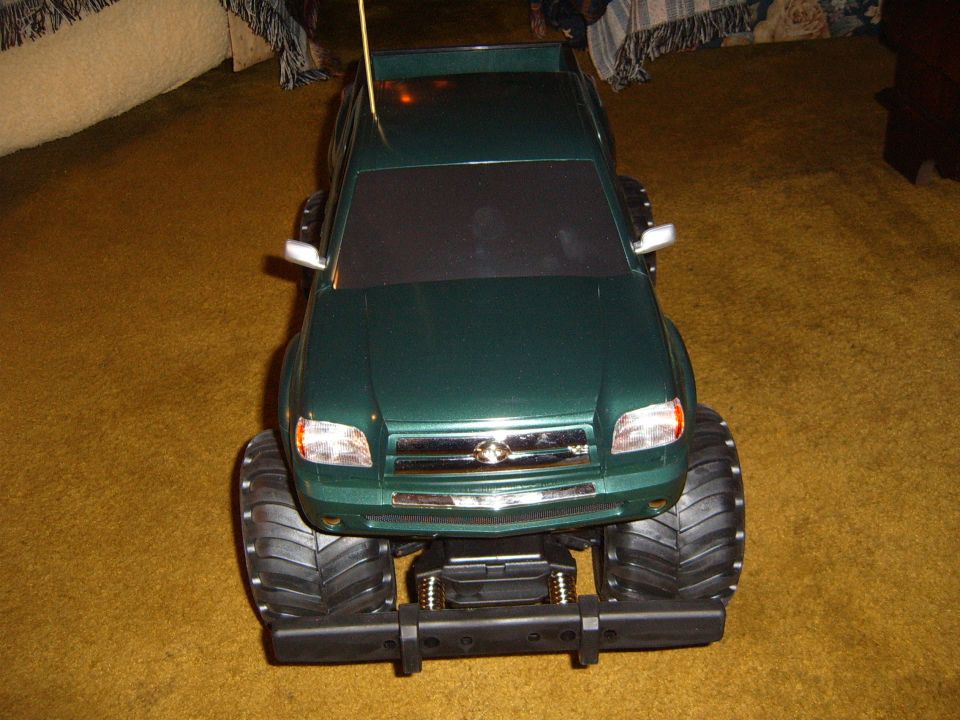 Green remote control monster truck with large tires, seen from the front