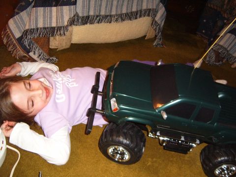 1993 Ford Bronco - A child lies on the floor next to a large, green toy monster truck.