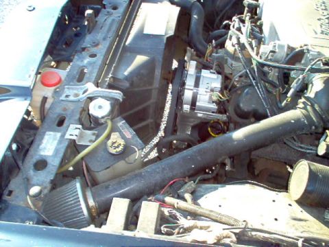 1985 Ford LTD Crown Victoria - Close-up view of the engine bay, showing the radiator, alternator, and various hoses and wiring.
