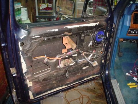 1984 Ford Bronco - The interior of a car door is shown with exposed wiring and a blue speaker, suggesting repair or modification work.