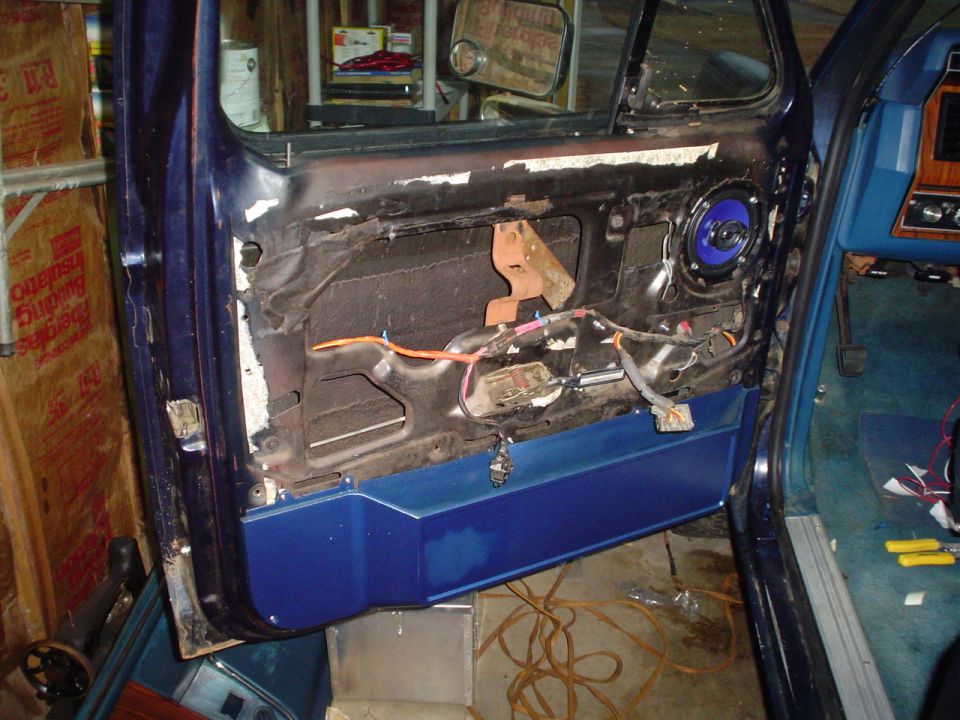 Door panel removed showing wiring and speaker. Blue door panel visible
