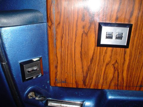 1984 Ford Bronco - The interior door panel features faux wood grain trim and controls for power windows and door locks.