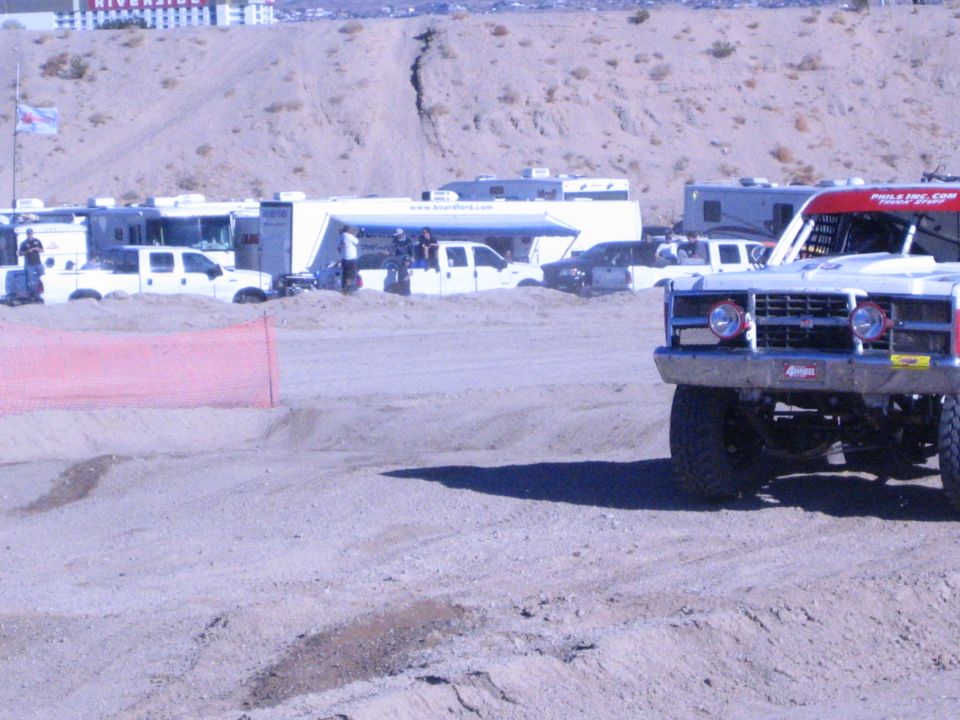 Front of a red and white off-road race truck on a desert dirt course
