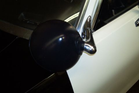 1991 Ford Crown Victoria - A black spotlight is mounted to a chrome mirror bracket on the side of a white vehicle.