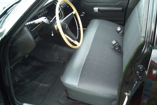 Car front bench seat and dashboard with light tan steering wheel